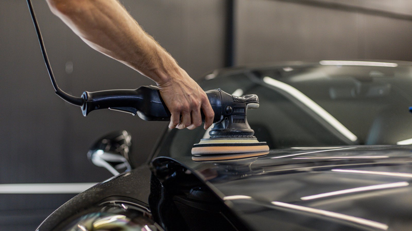 Auto detailer installing ceramic coating onto a Porsche